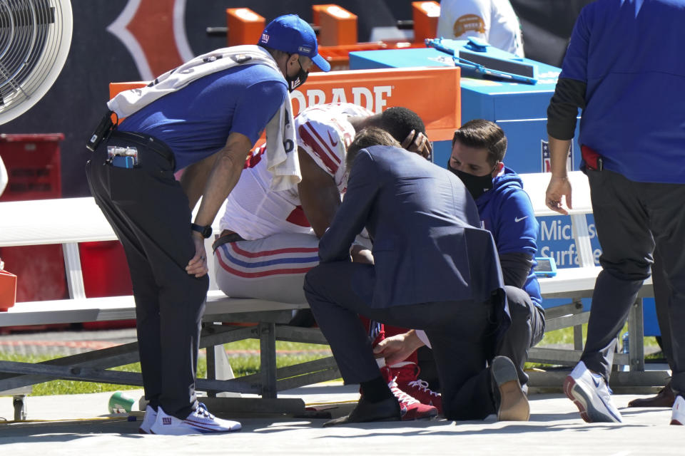 New York Giants running back Saquon Barkley is attended to on the bench by medical staff after being injured against the Chicago Bears during the first half of an NFL football game in Chicago, Sunday, Sept. 20, 2020. (AP Photo/Nam Y. Huh)