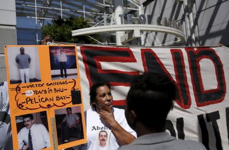 People carry signs at a rally at the Elihu Harris state building in Oakland, California, September 1, 2015. REUTERS/Robert Galbraith