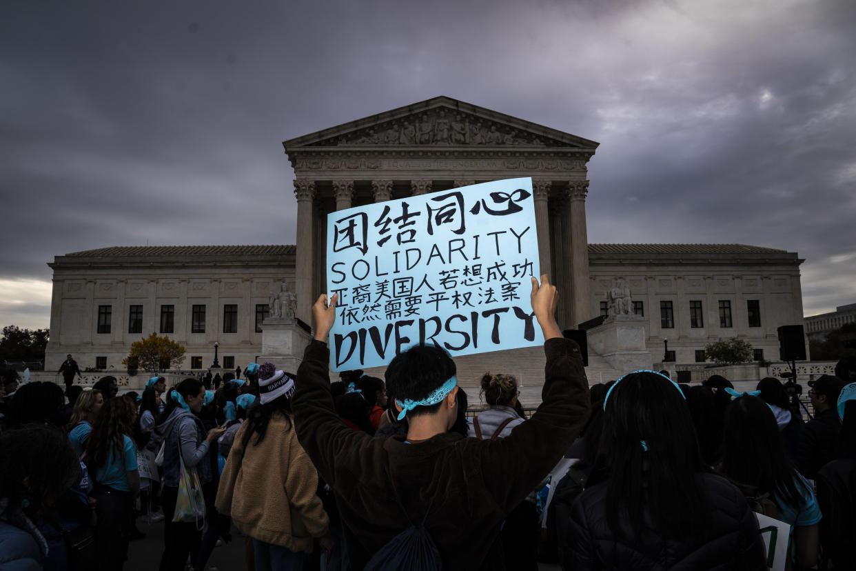 People outside the Supreme Court rally in support of affirmative action in college admissions. One person is holding a sign that reads: Solidarity. Diversity.