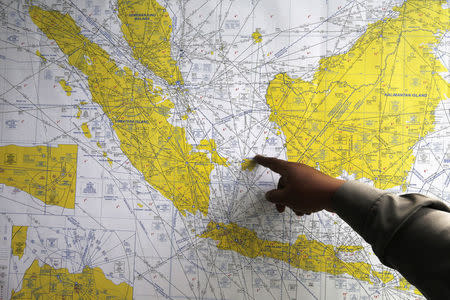 An Indonesian policeman points at a map of Indonesia at a crisis centre in Juanda International Airport, Surabaya December 29, 2014. REUTERS/Beawiharta