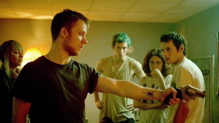 A man points a gun in a crowded room in Green Room.