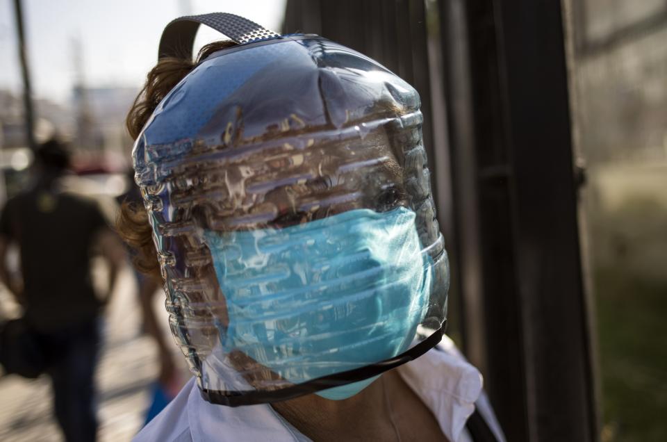 Venezuelan Elida Ludo wears a homemade face-shield to protect herself from the spread of the new coronavirus, as she waits in a line outside a public hospital in Lima, Peru, Monday, April 20, 2020. (AP Photo/Rodrigo Abd)