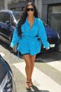 <p>In a Louis Vuitton turquoise belted shirtdress, grey biker shorts, black heels and oversized sunglasses while attending the men's Louis Vuitton fashion show in Paris. </p>