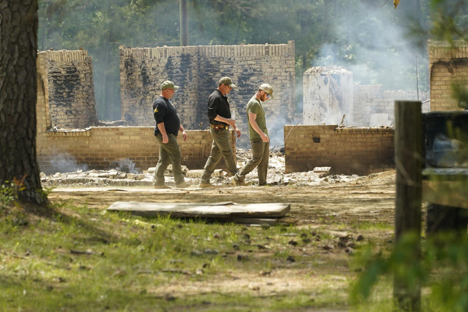 Investigators look around the remnants of a burned out house where authorities believe a man who escaped from a Mississippi jail over the weekend with three others, and is suspected of killing a pastor, is believed to be dead after a shootout with authorities and barricaded himself inside a burning home near Conway, Mississippi, Wednesday morning, April 26, 2023. (AP Photo/Rogelio V. Solis)