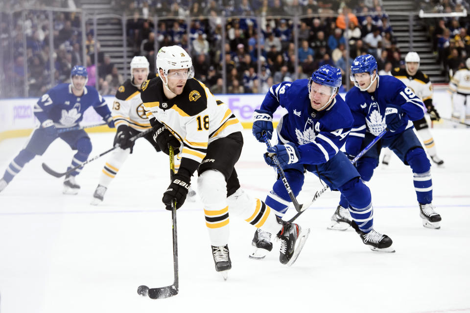 Boston Bruins forward Pavel Zacha (18) looks for a pass under pressure from Toronto Maple Leafs defenseman Morgan Rielly (44) during the first period of an NHL hockey game, Saturday, Nov. 5, 2022 in Toronto. (Christopher Katsarov/The Canadian Press via AP)