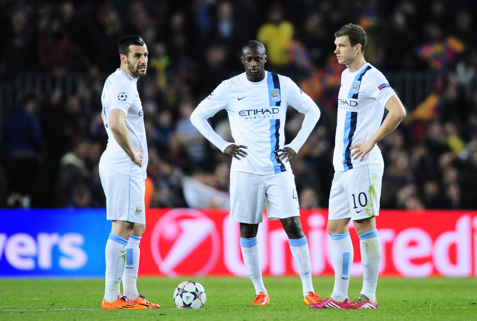 Manchester City's Alvaro Negredo, Yaya Toure and Edin Dzeko, from left to right, react after Barcelona scored the second goal during a Champions League, round of 16, second leg, soccer match between FC Barcelona and Manchester City at the Camp Nou Stadium in Barcelona, Spain, Wednesday March 12, 2014. (AP Photo/Manu Fernandez)