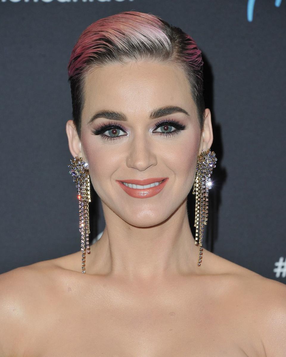 <p>Queen of rainbow hair transformations, Katy Perry, worked a pastel pink pixie crop with grown out roots.</p>