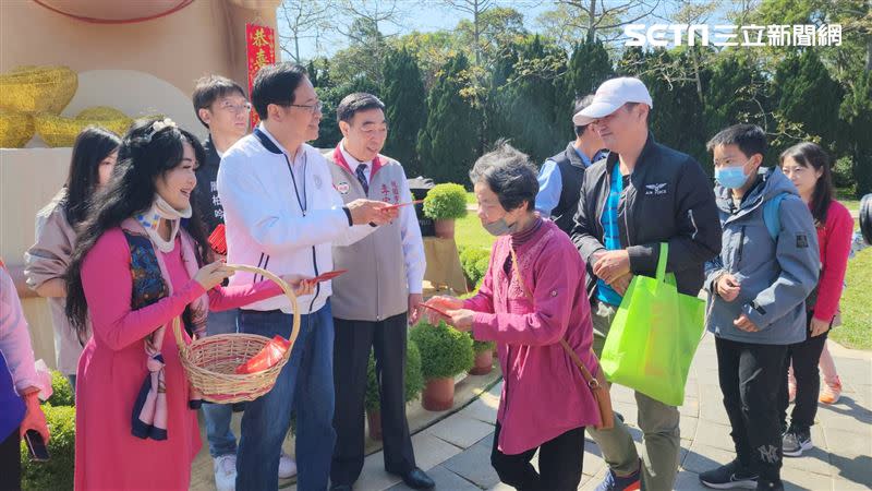 張善政與妻子在「水豚財神」前發放福袋，瞬間成為園區最多人拍照打卡景點。（圖／埔心牧場提供）