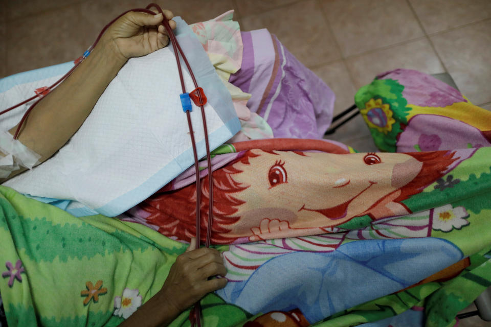 Maria Esis, 52, a patient with kidney disease, rests during a dialysis session at a dialysis center after a blackout in Maracaibo, Venezuela. (Photo: Ueslei Marcelino/Reuters)