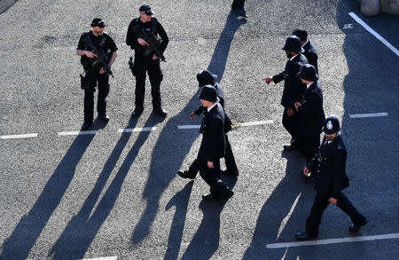 Armed police officers stand guard as uniformed police walk past them, ahead of Prince Harry and Meghan Markle's wedding in Windsor, Britian May 19, 2018. REUTERS/Dylan Martinez