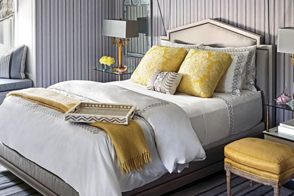 <p>Pops of sunny yellow and white steal the show in this inviting guest bedroom, which is outfitted in a striped wall covering.</p>