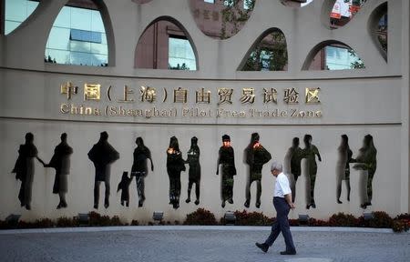 A man walks at the entrance of the Shanghai Free Trade Zone in Pudong district, in Shanghai September 14, 2014. REUTERS/Carlos Barria