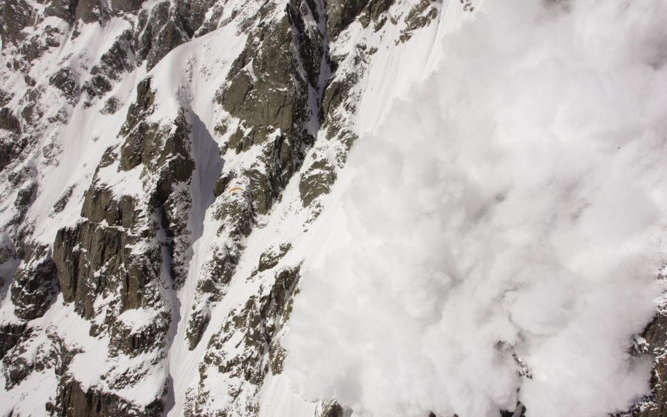 An avalanche on Nanga Parbat: the yellow wing of Silvester's paraglider can just be made out to the left of the snowfall halfway down the photograph - Olivier Laugero