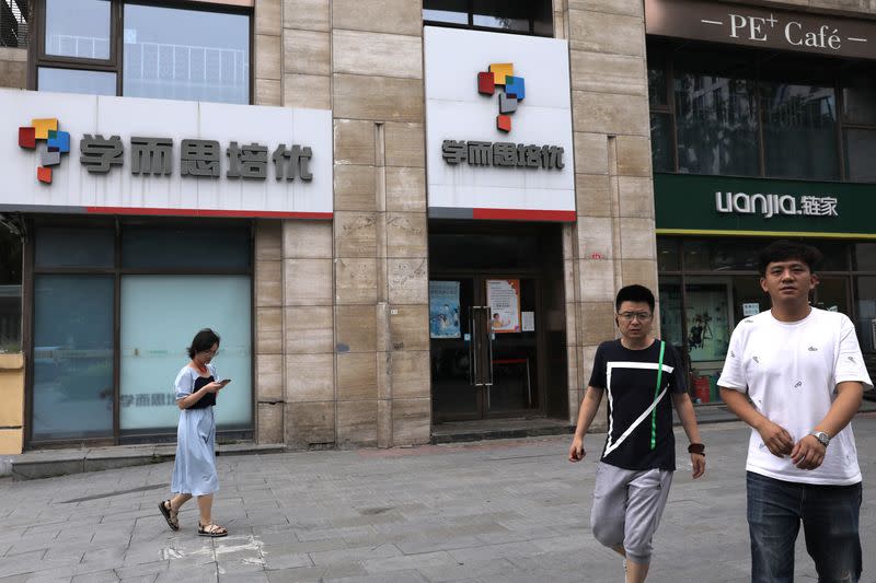 People walk past a Xueersi outlet, a private educational services provider owned by TAL Education Group, in Beijing