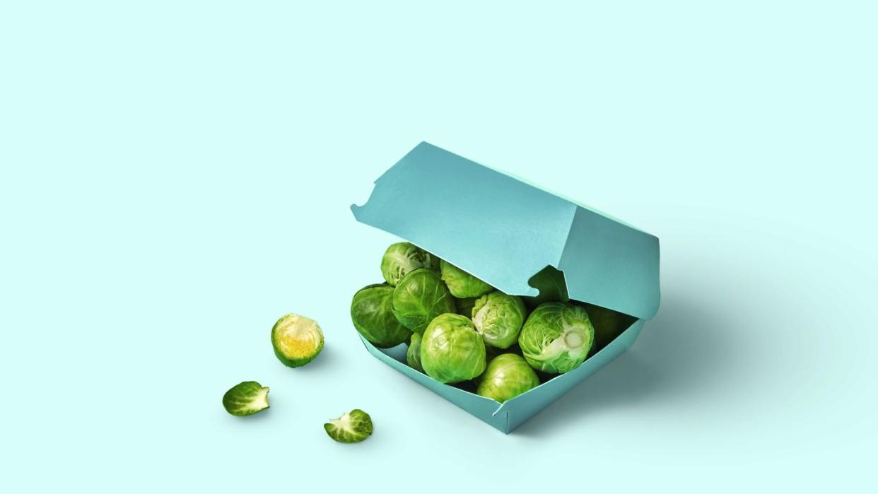 fresh raw brussels sprouts lying inside paper burger box over light blue background ripe cabbage from farm healthy eating