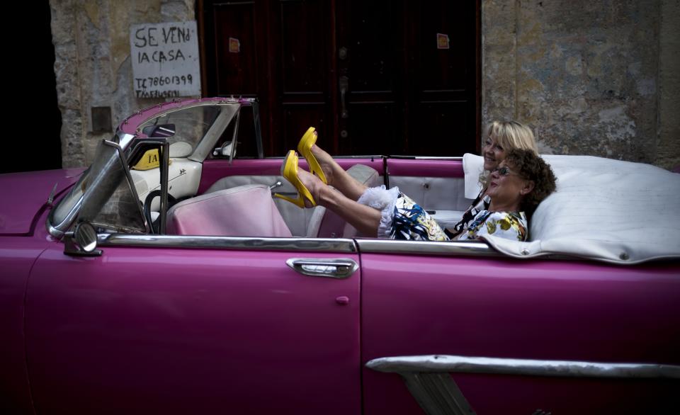 <p>Eine Touristin legt in einem pinkfarbenen Cabrio die Beine hoch. Der Wagen der Marke Chevrolet ist ein privates Taxi, das Gäste durch die kubanische Hauptstadt Havanna fährt. (Bild: AP Photo) </p>