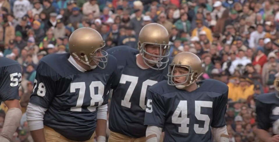 A group of football players prepare for a play