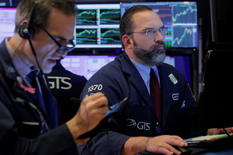 Traders work on the floor at the NYSE in New York