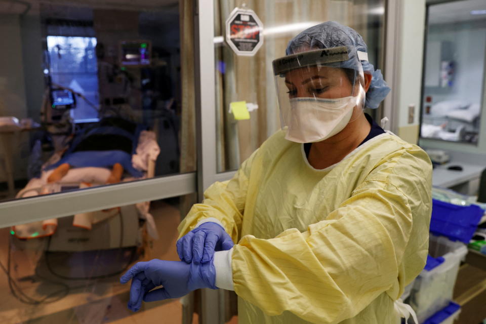 Sabrina Stewart, registered charge nurse, prepares to enter the room of a COVID patient in their isolation room at Western Reserve Hospital in Cuyahoga Falls, Ohio, January 4, 2022 amid the spread of omicron. REUTERS/Shannon Stapleton