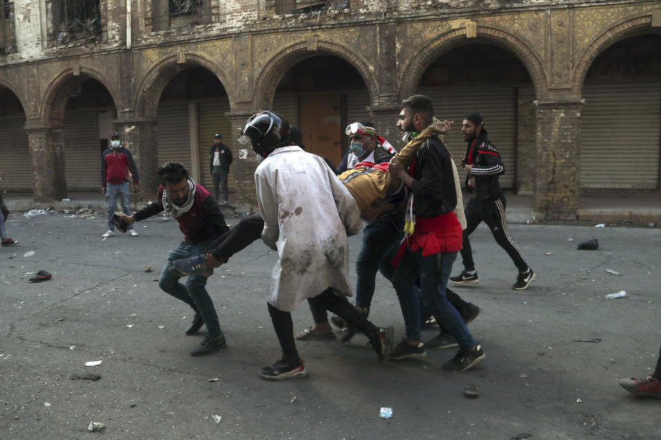 An injured protester is rushed to a hospital during clashes between security forces and anti-government demonstrators in Baghdad, Iraq, Friday, Nov. 22, 2019. Iraq's massive anti-government protest movement erupted Oct. 1 and quickly escalated into calls to sweep aside Iraq's sectarian system. Protesters occupy several Baghdad squares and parts of three bridges in a standoff with security forces. (AP Photo/Hadi Mizban)