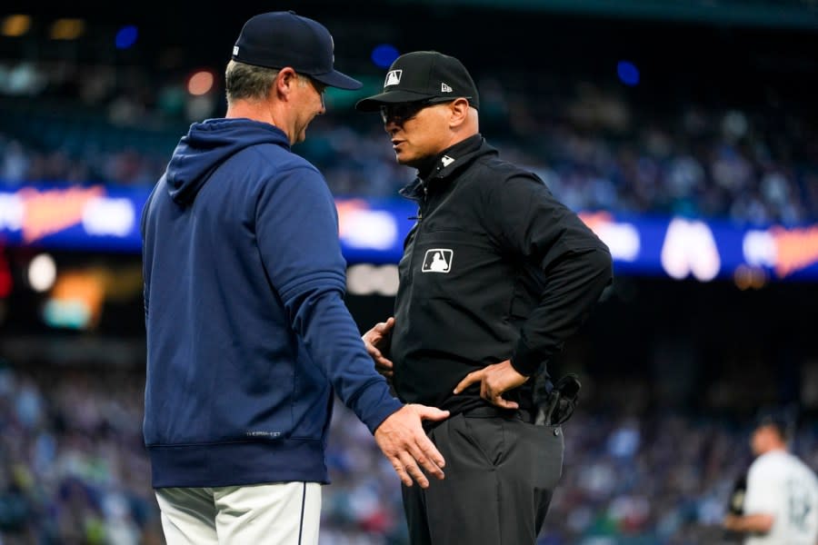 Seattle Mariners manager Scott Servais, left, talks with second base umpire Vic Carapazza after Mariners’ Dylan Moore was ejected from the dugout while arguing about an overturned call that Guardians’ Ramon Laureano was hit by a pitch during the third inning of a baseball game Monday, April 1, 2024, in Seattle. (AP Photo/Lindsey Wasson)