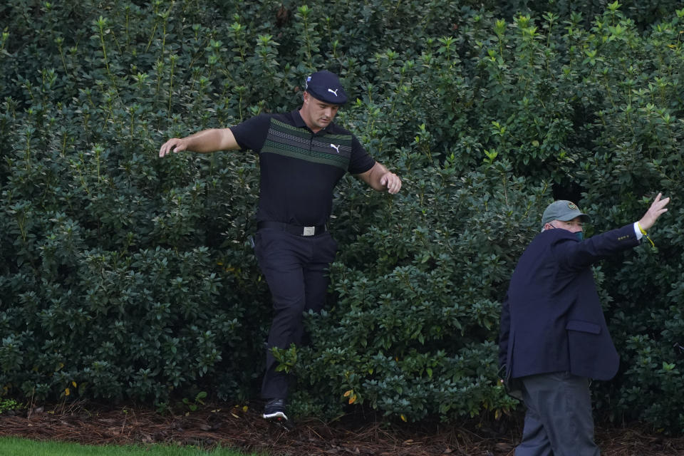 Bryson DeChambeau comes out of the bushes after looking for his ball in the bushes on the 13th hole during the first round of the Masters golf tournament Thursday, Nov. 12, 2020, in Augusta, Ga. (AP Photo/Chris Carlson)