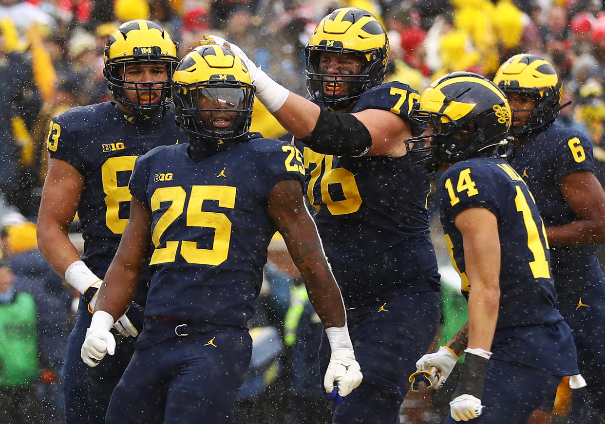 ANN ARBOR, MICHIGAN - NOVEMBER 27: Hassan Haskins #25 of the Michigan Wolverines celebrates with teammates after his touchdown against the Ohio State Buckeyes during the second quarter at Michigan Stadium on November 27, 2021 in Ann Arbor, Michigan. (Photo by Mike Mulholland/Getty Images)