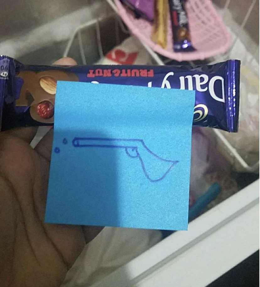 A Post-It with a gun on it taped to candy