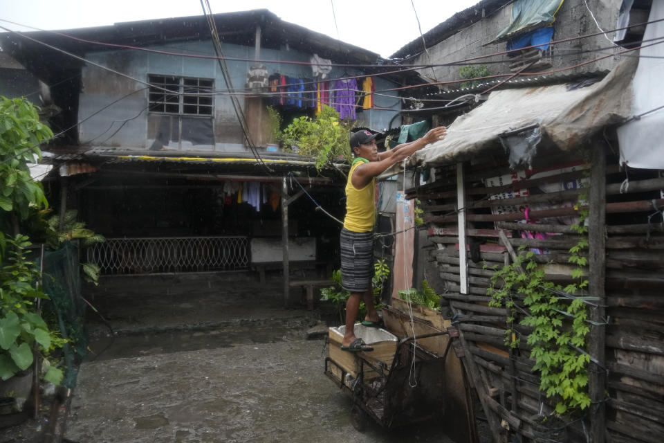 A resident secures his roof as Typhoon Noru approaches the seaside slum district of Tondo in Manila, Philippines, Sunday, Sept. 25, 2022. The powerful typhoon shifted and abruptly gained strength in an "explosive intensification" Sunday as it blew closer to the northeastern Philippines, prompting evacuations from high-risk villages and even the capital, which could be sideswiped by the storm, officials said. (AP Photo/Aaron Favila)