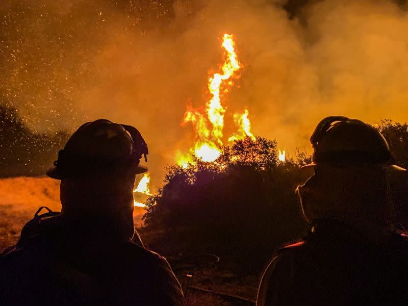 Firefighters work to extinguish a fire in Alpine, California