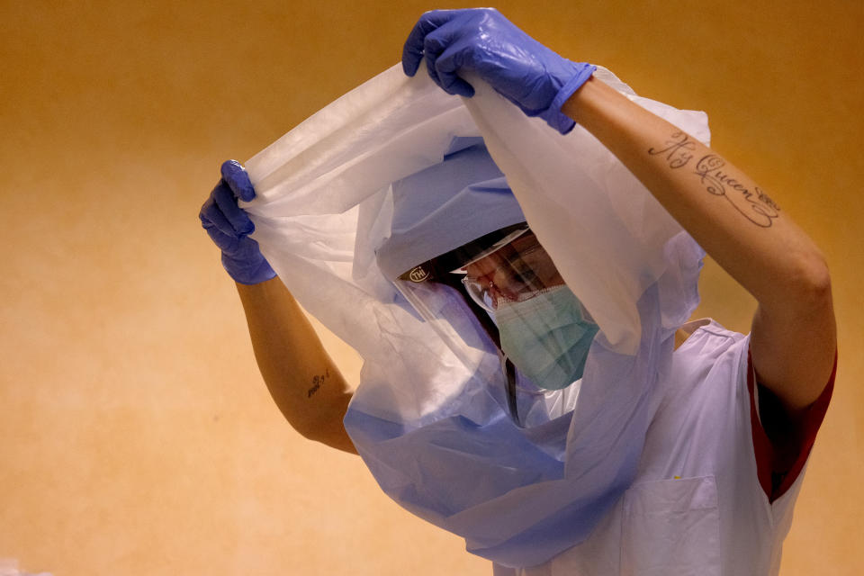 A nurse dresses up to enter the intensive care unit of the COVID-19 department of the Policlinic of Tor Vergata in Rome, Friday, April 17, 2020. After an unfortunate start that caused a heavy toll of victims among medical personnel at the beginning of the coronavirus outbreak in Italy, extreme precaution in wearing protections is now a must in all hospital treating the infection. (Mauro Scrobogna/LaPresse via AP)