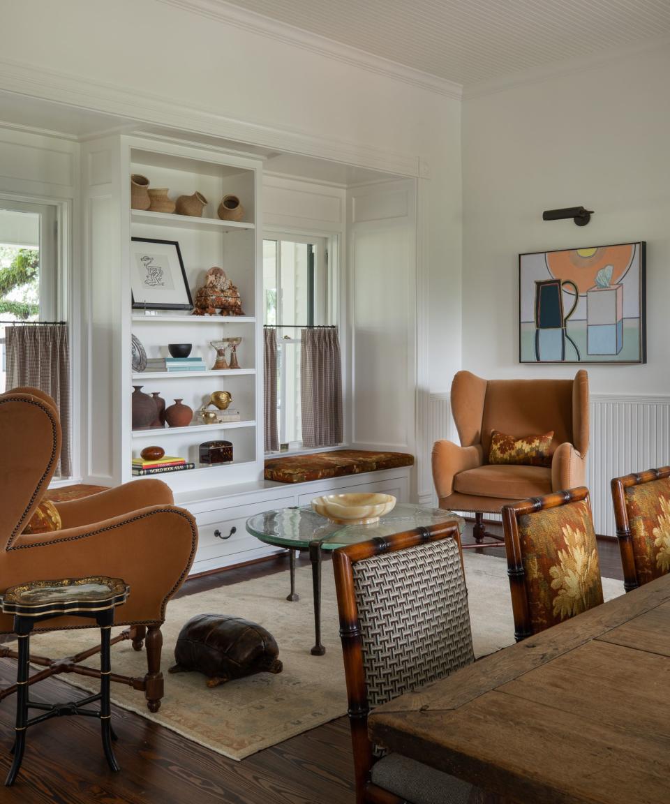 breakfast nook with two mustard armchairs and white shelves with window seats