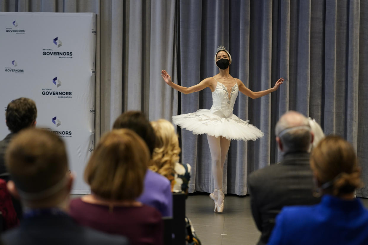 Eun Won Lee from Korea performs the White Swan pas de deux from SWAN LAKE for first lady Jill Biden and second gentleman Doug Emhoff, seated right, and others at the annual NGA Spouses Breakfast at the Kennedy Center in Washington, Monday, Jan. 31, 2022. (AP Photo/Carolyn Kaster)