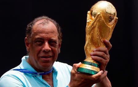 Former Brazilian soccer captain Carlos Alberto Torres holds the 2014 FIFA World Cup Brazil trophy during its unveiling ceremony at a Soccerex event at Copacabana beach in Rio de Janeiro, November 21, 2010. REUTERS/Bruno Domingos/Files