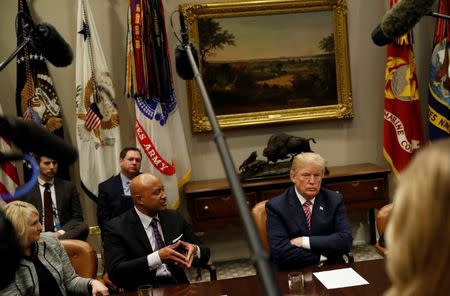 U.S. President Donald Trump listens to Attorney General Curtis Hill (R-IN), left, during a meeting with local and state officials about improving school safety at the White House in Washington, U.S., February 22, 2018. REUTERS/Leah Millis