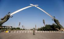 FILE PHOTO: An Iraqi security officer walks near the "Arch of Victory" memorial in the Green Zone of Baghdad