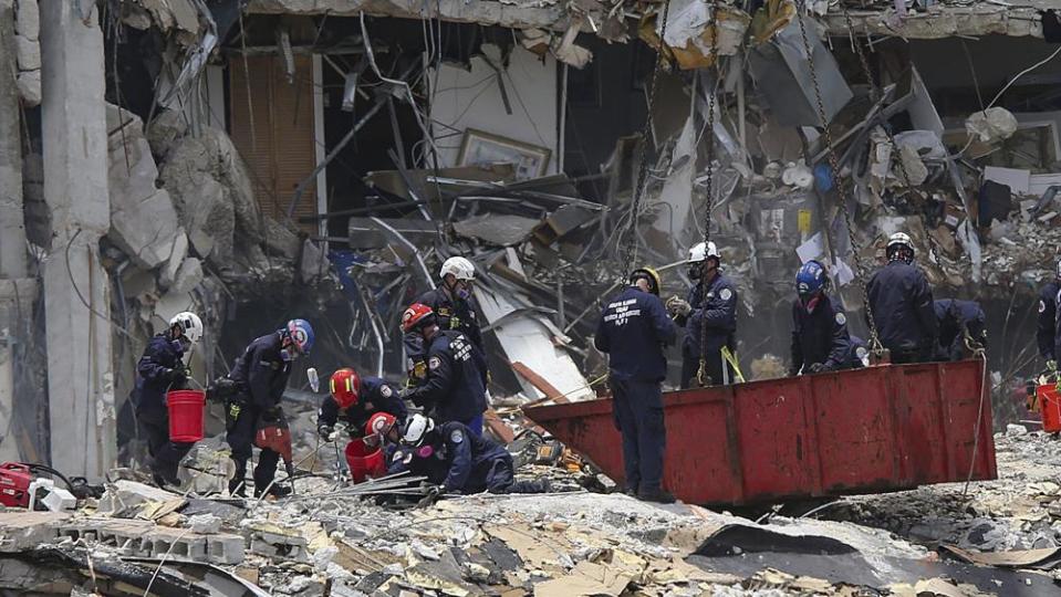 South Florida Urban Search and Rescue team look for survivors at the 12-story oceanfront condo, Champlain Towers South on Saturday, June 26, 2021 that partially collapsed early Thursday morning in the Surfside area of Miami. (Al Diaz/Miami Herald via AP)