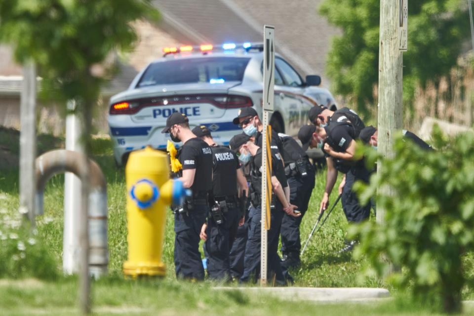 Police officers look for evidence in London, Ontario, after four family members were killed by a truck (Geoff Robins/The Canadian Press via AP)