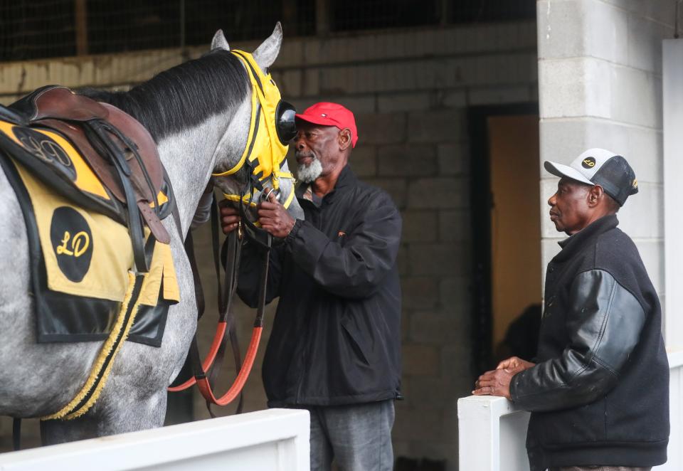 Trainer Larry Demeritte, right, checks out Kentucky Derby hopeful West Saratoga as brother Patrick Demeritte holds the reins before a morning workout at Keeneland in Lexington, Ky. on April 19, 2024. “When you grow up in the sport, it’s different than when you walk into it,” Patrick Demeritte said. “We learned the sport without getting a paycheck. We don’t worry about the money part of it. We deal with the horse and let the horse take us through.”