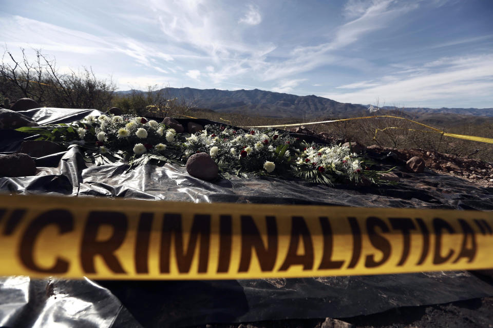 FILE - This Jan. 12, 2020 file photo shows flowers placed by relatives on the remains where one of the cars belonging to the extended LeBaron family was ambushed by gunmen last year, near Bavispe, Sonora state, Mexico. Julian LeBaron, a prominent member of the community of U.S.-Mexican dual citizens living in northern Mexico that was shattered by the November massacre of three women and six children along a rural road has fled to the United States after an apparent threat on his life. (AP Photo/Christian Chavez, File)