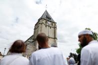 Muslims hold a minute of silence on July 29, 2016 in front of the church if Saint-Etienne-du-Rouvray, where French priest Jacques Hamel was killed