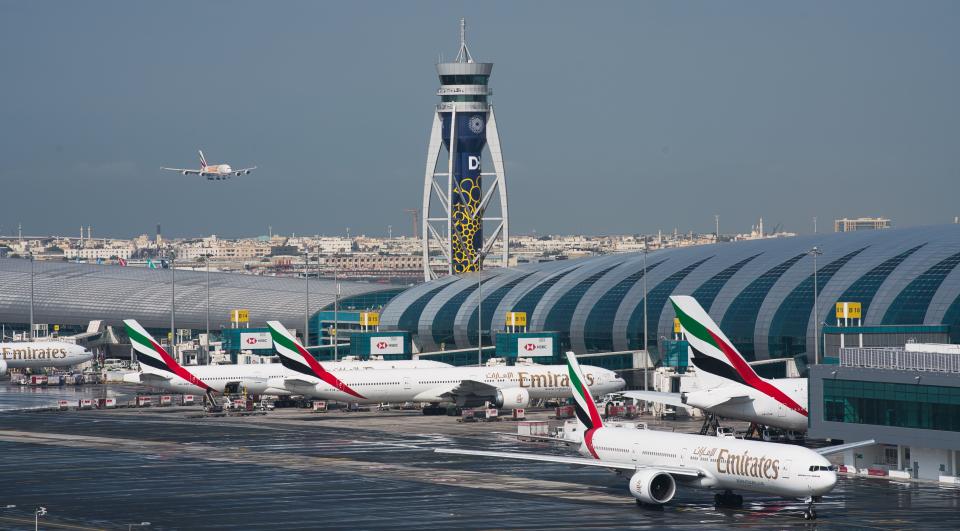 FILE - In this Dec. 11, 2019 file photo, an Emirates jetliner comes in for landing at Dubai International Airport in Dubai, United Arab Emirates. On Sunday, March 22, 2020, long-haul carrier Emirates said it would suspend all passenger flights beginning Wednesday, March 25, 2020, over the effects of the global new coronavirus pandemic. (AP Photo/Jon Gambrell, File)