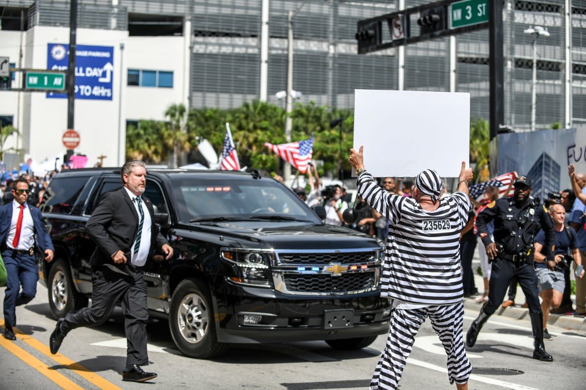 Dramatic moment protestor Domenic Santana of Miami, Florida, runs out in front of former President Donald Trump’s motorcade (EPA)
