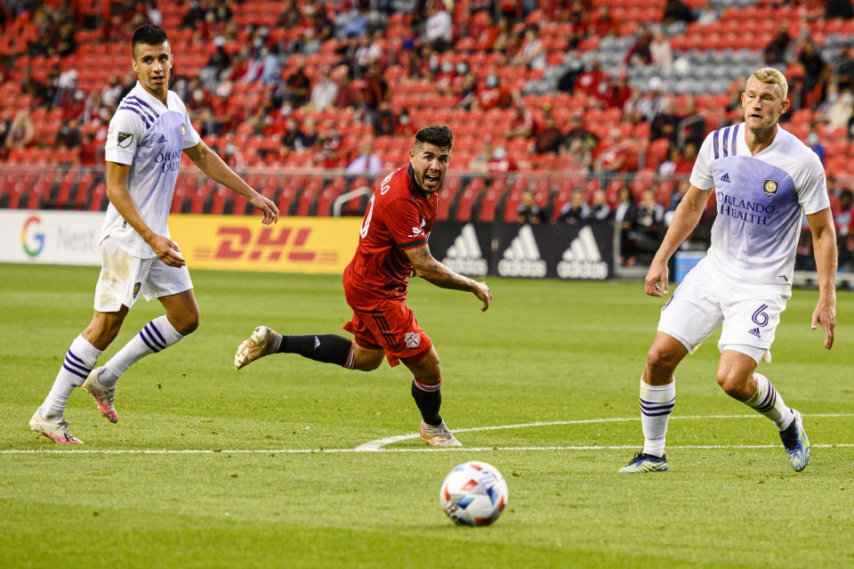 Toronto FC midfielder Alejandro Pozuelo, center, looks for the ball as Orlando City SC's Joao Moutinho, left, and Robin Jansson defend during first-half MLS soccer match action in Toronto, Saturday, July 17, 2021. (Chris Katsarov/The Canadian Press via AP)