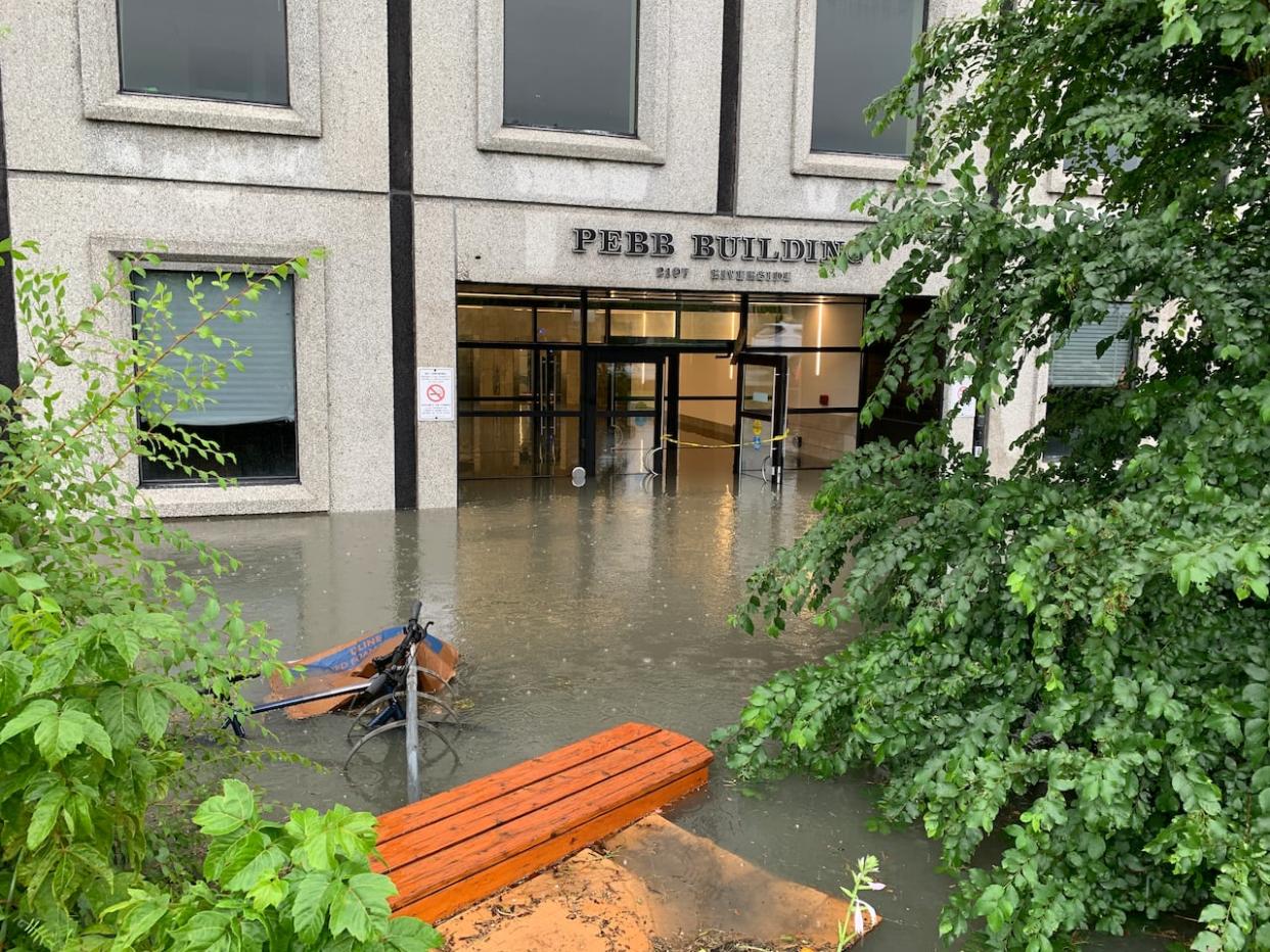Heavy rain flooded the entrance of the Pebb Building on Riverside Drive near Bank Street on Aug. 10, 2023. The flooding damaged at least 486 homes, though staff suggest the number could be much higher.  (Guy Quenneville/CBC News - image credit)