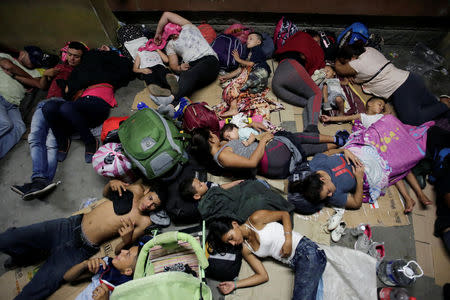 Hondurans fleeing poverty and violence, rest before moving in a caravan toward the United States, outside the bus station in San Pedro Sula, Honduras October 13, 2018. REUTERS/Jorge Cabrera