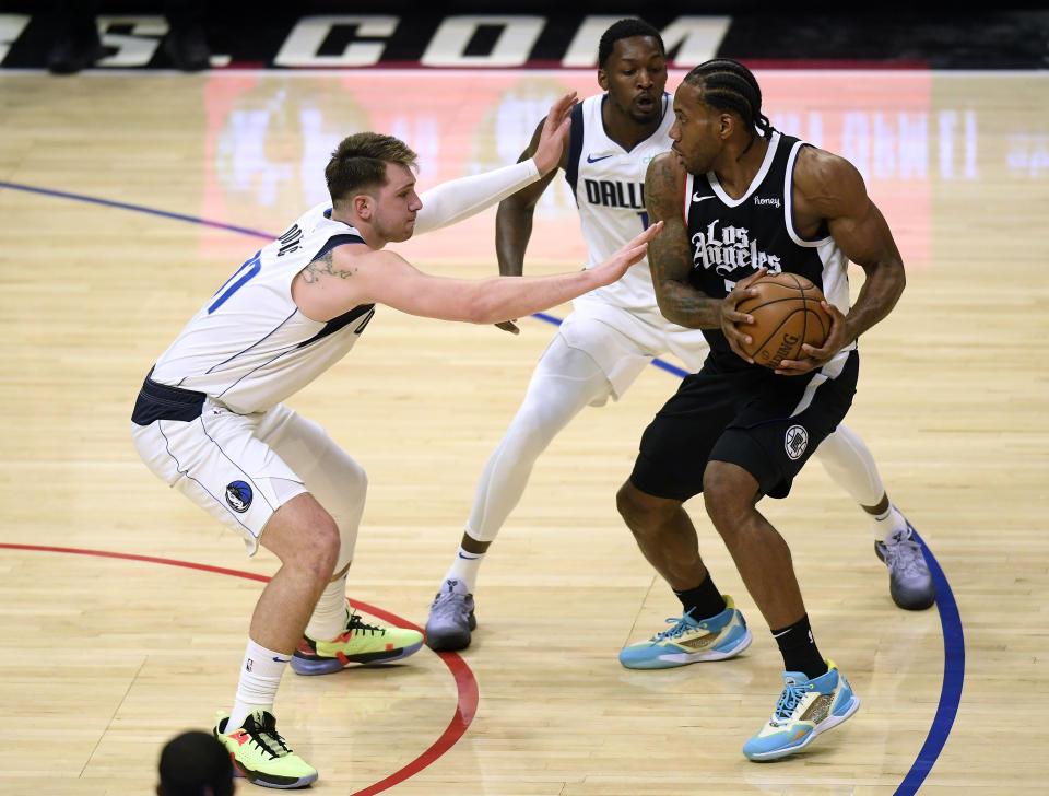 Kawhi Leonard #2 of the LA Clippers is double teamed by Luka Doncic #77 and Dorian Finney-Smith #10 of the Dallas Mavericks in the second quarter during game one of the Western Conference first round series at Staples Center on May 22, 2021 in Los Angeles, California. NOTE TO USER: User expressly acknowledges and agrees that, by downloading and or using this photograph, User is consenting to the terms and conditions of the Getty Images License Agreement. (Photo by Harry How/Getty Images)