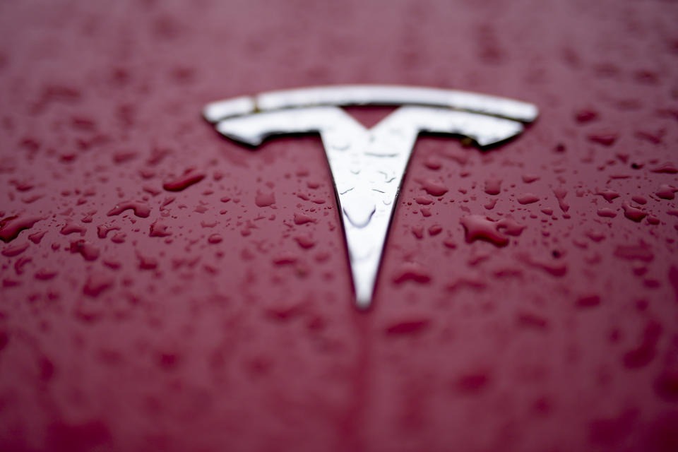 A Tesla logo has rain drops on it Tuesday, Feb. 27, 2024, in Charlotte, N.C. In campaigns for Congress and for governor around the country, candidates are talking about how green the grid should be. (AP Photo/Chris Carlson)