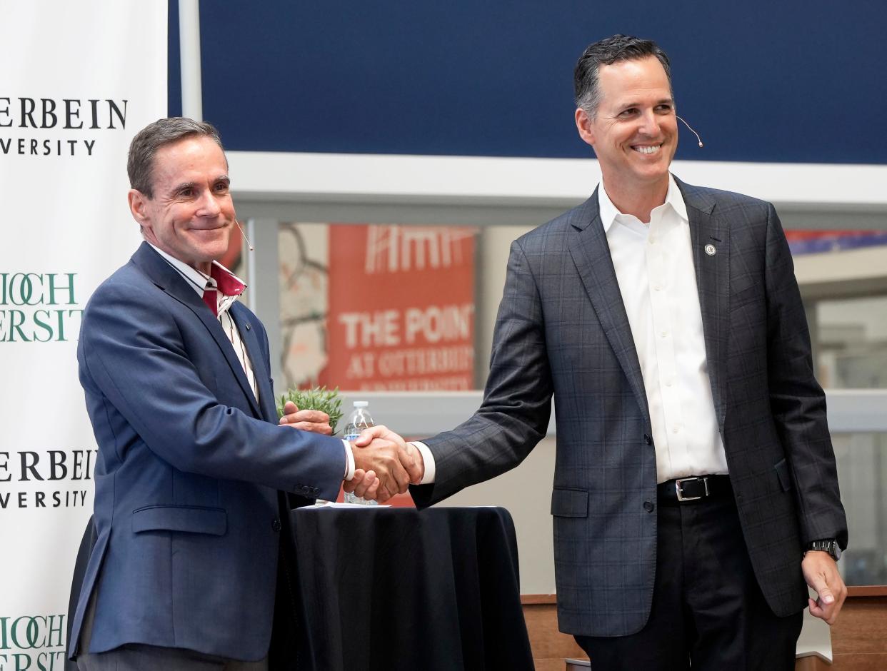 Chancellor William R. Groves of Antioch University, left, shakes hands with President John Comerford of Otterbein University, right, after a news conference announcing a partnership between the two schools in July 2022 at The Point at Otterbein in Westerville.