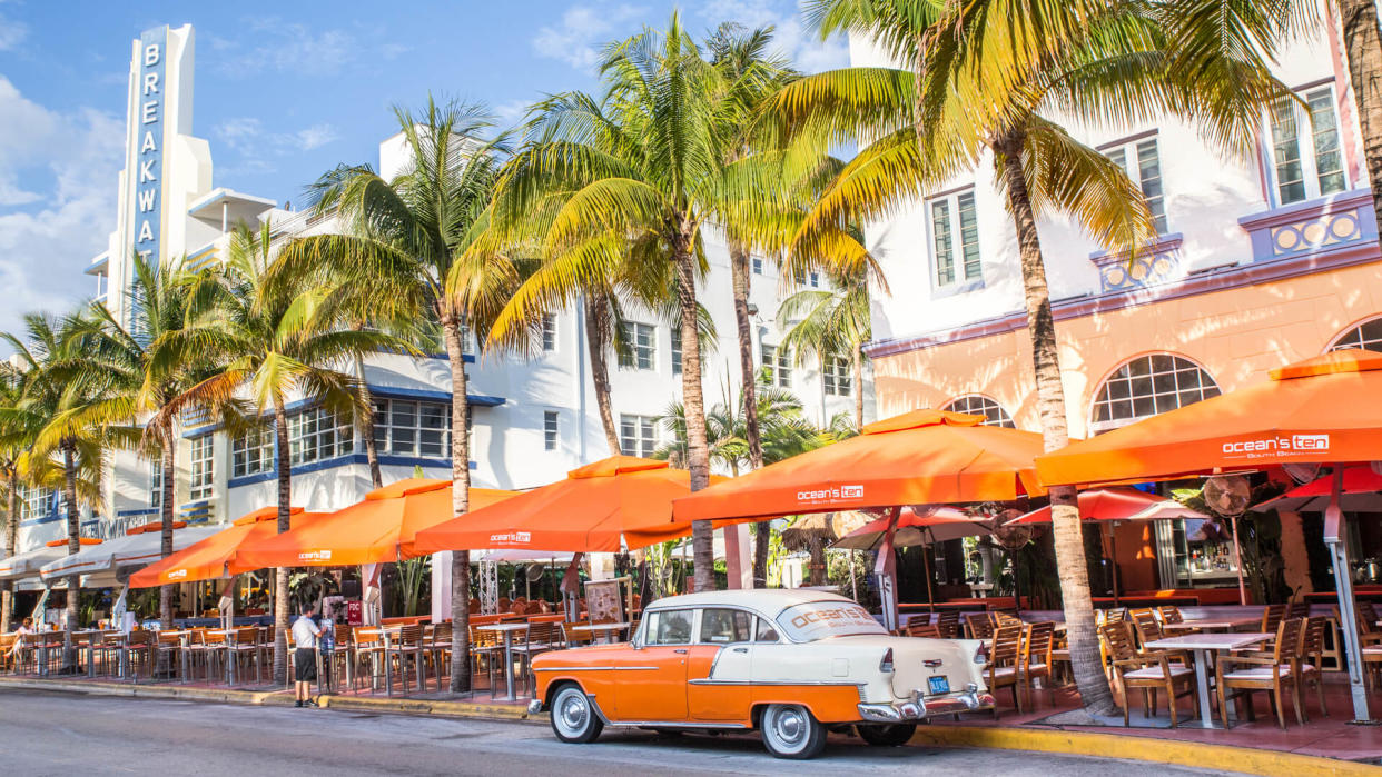 Miami Beach, Florida, USA - April 25, 2016:   View along Ocean Drive along South Beach Miami in the historic Art Deco District with hotels, restaurant, people and classic car visible.